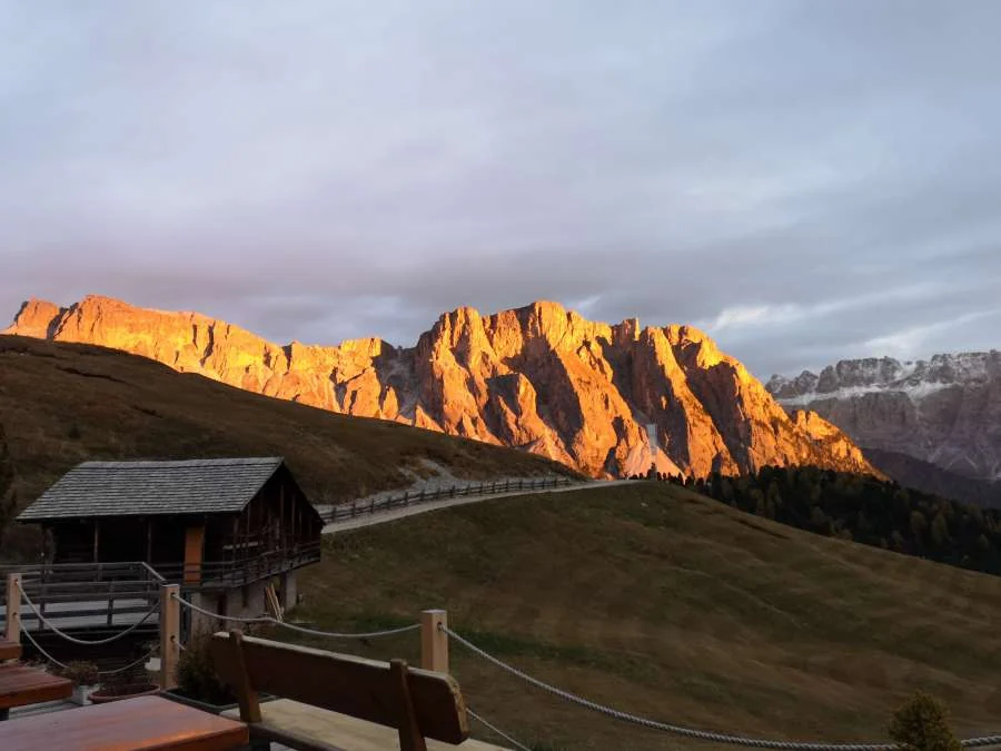 Alpenglühen auf den Felsen der Geislergruppe über der Alm