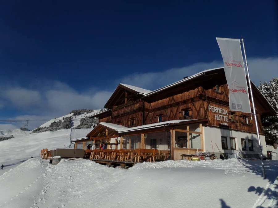 Die Fermeda Hütte im Schnee vor den Felsen der Geislergruppe