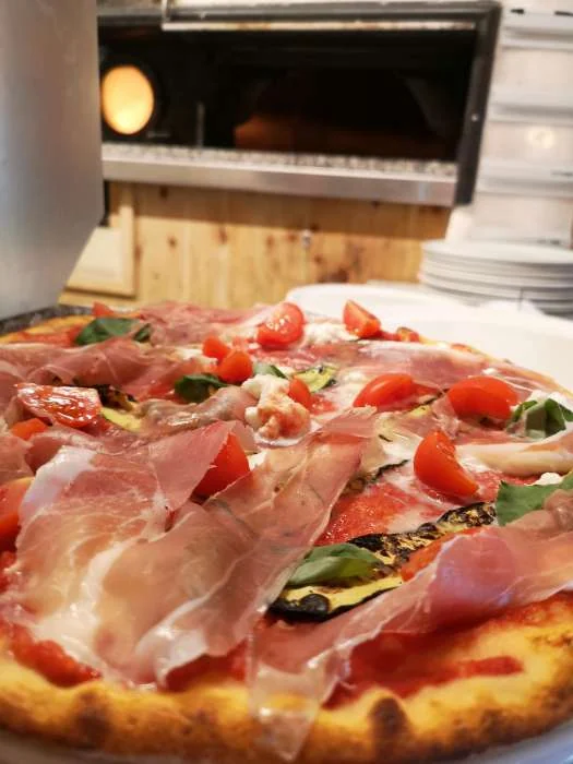 Pizza mit Schinken und Rucola aus dem Holzofen