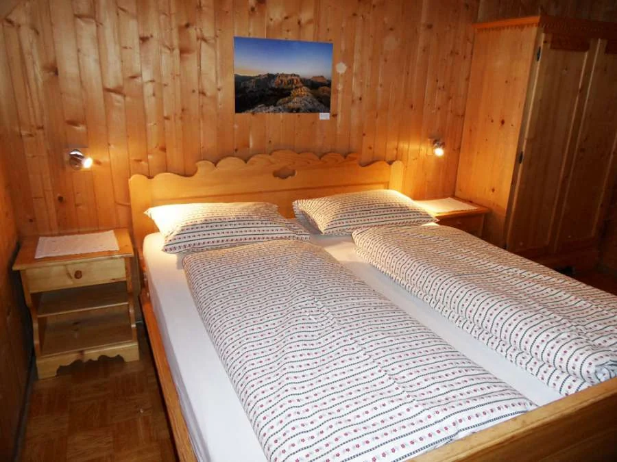 Doppelzimmer mit Holzbett und Holzvertäfelung